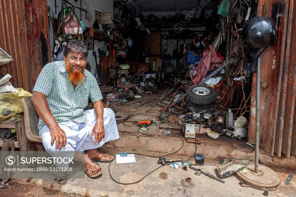 Local, Sinhalese man sitting in front of his garage, Beruwela, Western Province, Sri Lanka