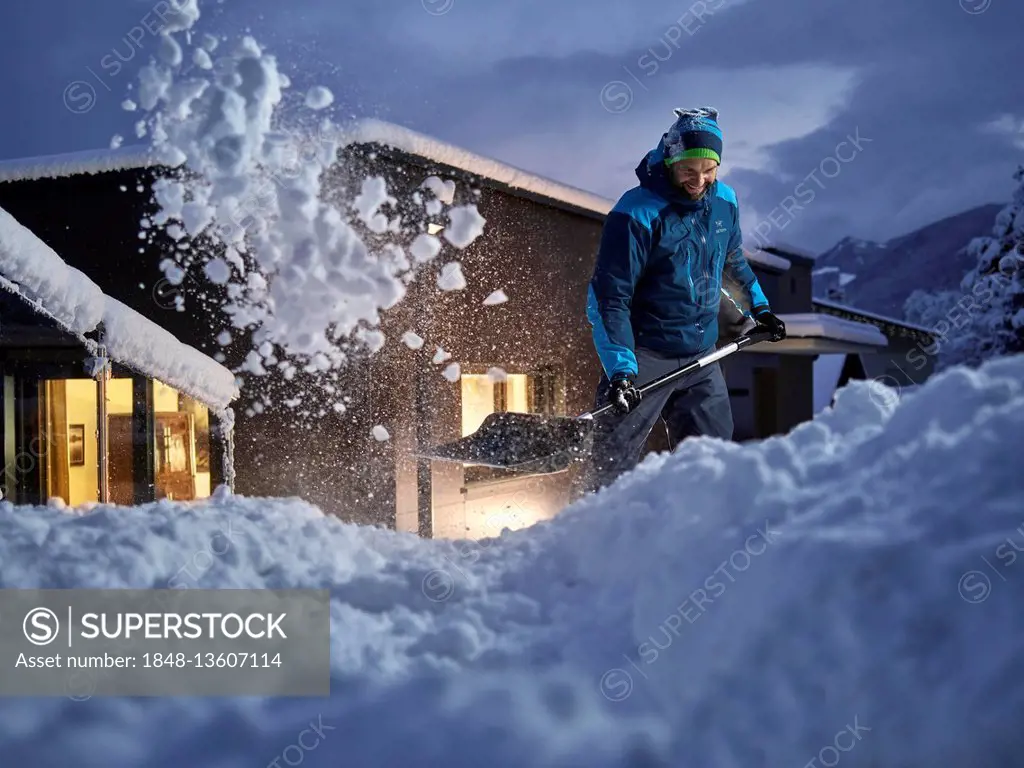 Man, 35-40 years, shoveling snow at dusk, Kolsass, Tyrol, Austria