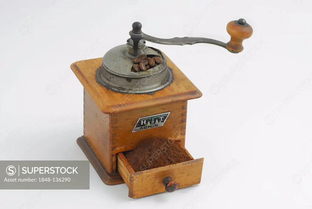 Antique wooden coffee mill with a drawer full of ground coffee