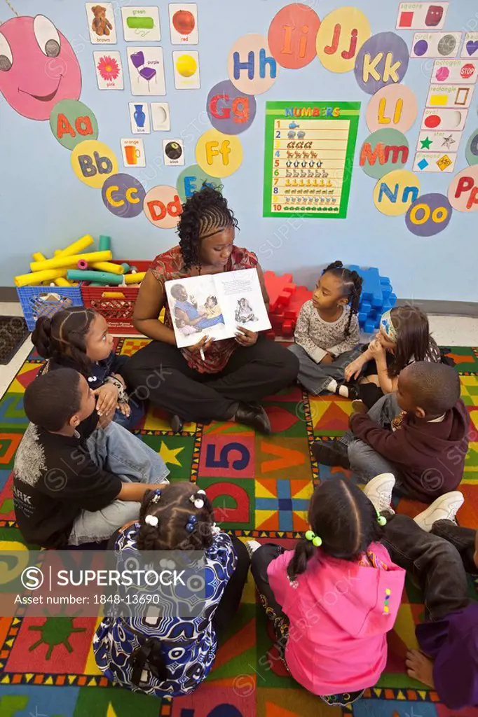 A teacher reads a story to children at a child care center, Detroit, Michigan, USA