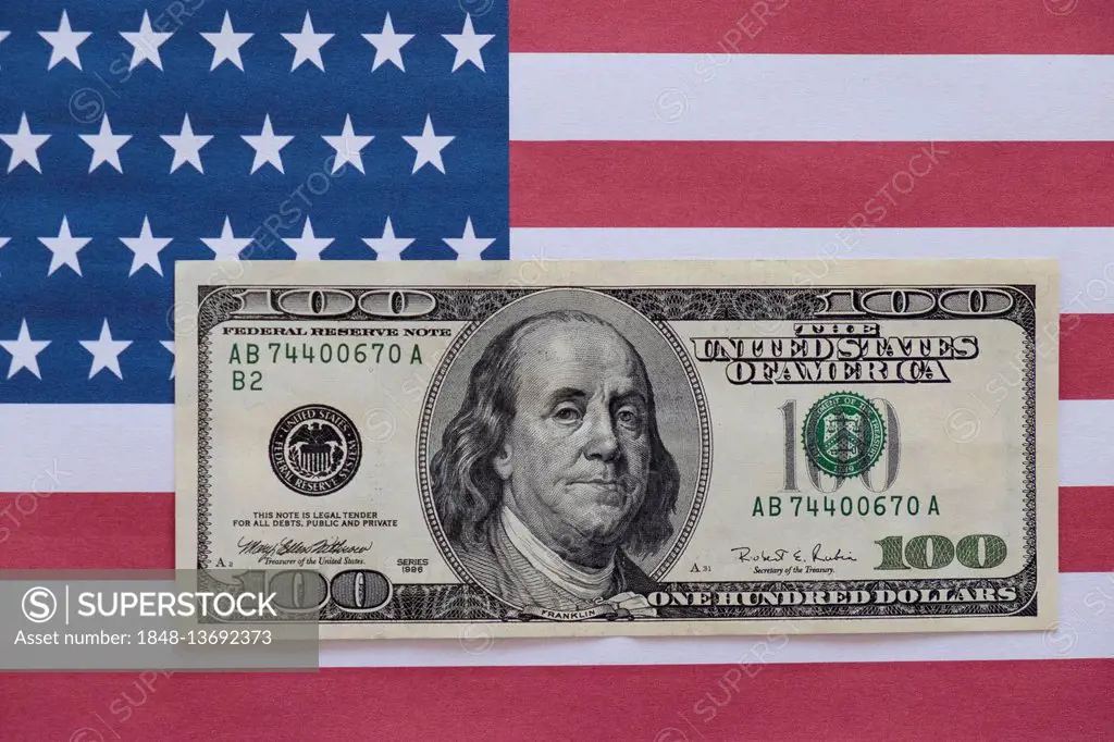100 US dollar bill on US flag