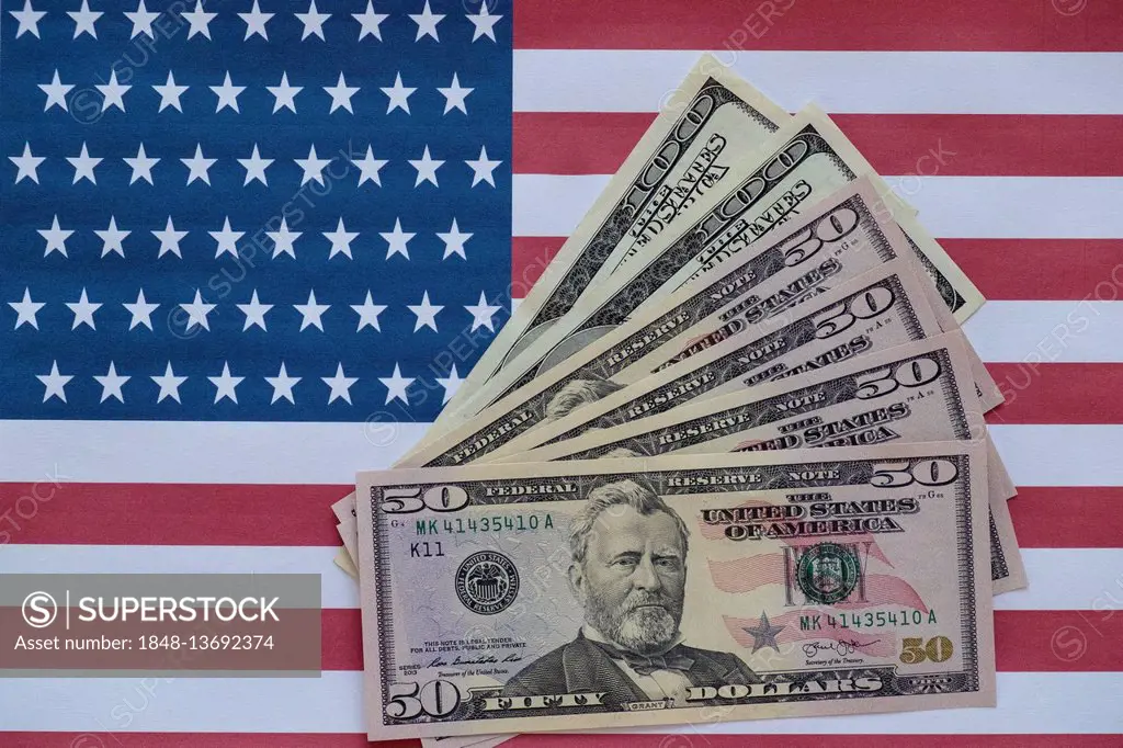 Various US dollar bills on American flag