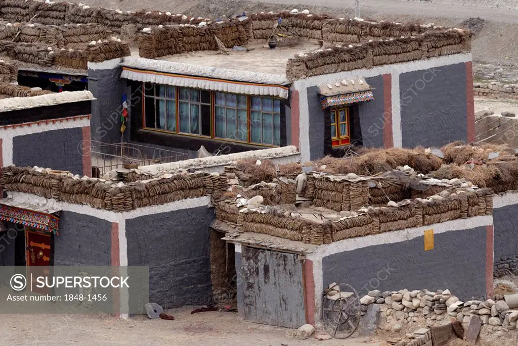 Tibetan house in Sakya style with Tibetan painting and yak dung for burning material drying on the compacted clay flat roofs, Sakya, Central Tibet, Ti...
