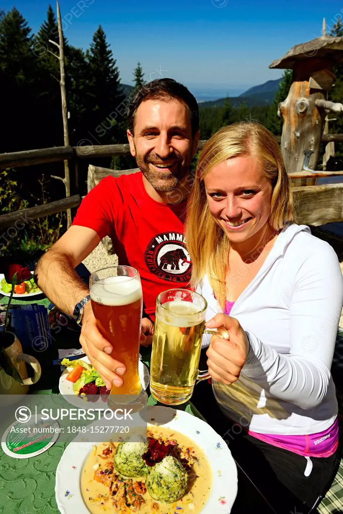 Hiker couple enjoying a snack on the Hindenburghütte, Reit im Winkl, Chiemgau, Upper Bavaria, Germany