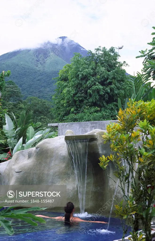 A woman is relaxing in a Thermal bath close to the volcano Arenal, La Fortuna, Costa Rica, Central America