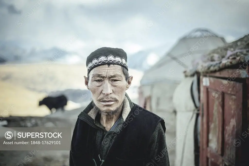 Portrait village headman, Kyrgyz nomadic settlement, behind him a yak, a yurt and the snow-covered peaks of the Hindu Kush, Khadz Goz, Wakhan Corridor...