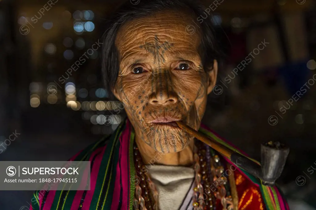 Chin woman with spiderweb tattoo smoking a pipe, Mindat, Chin state, Myanmar, Asia