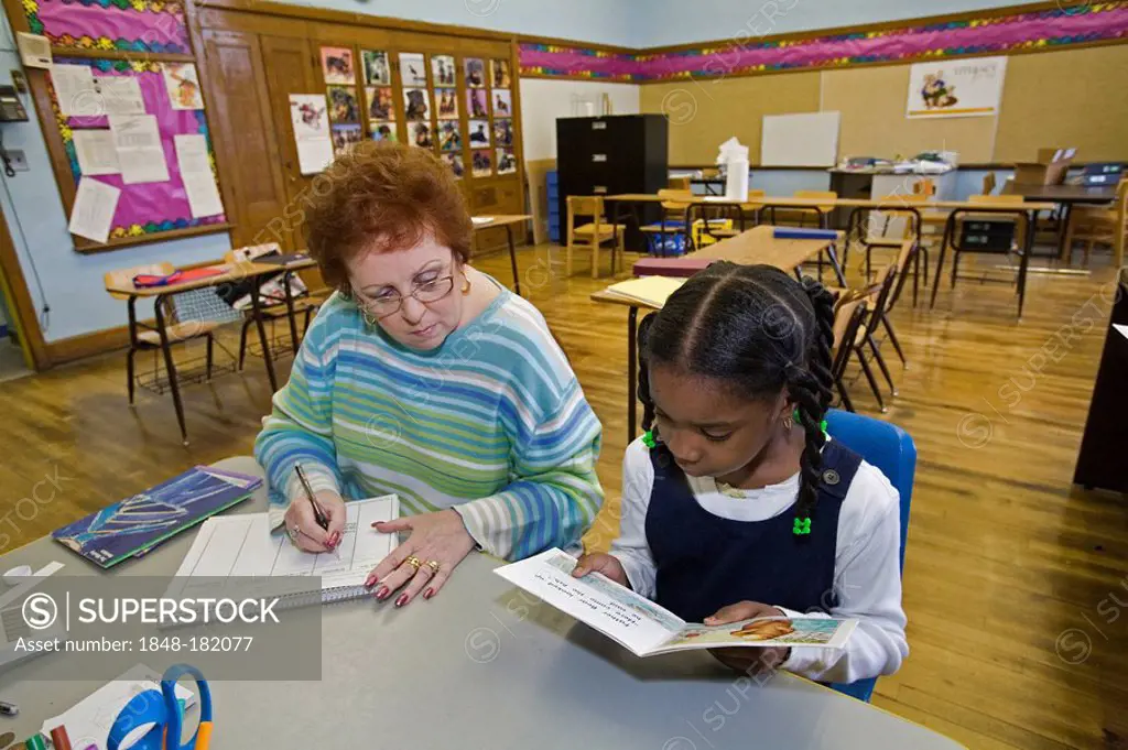 A teacher works with a student in a reading program at Guyton Elementary School, Detroit, Michigan, USA