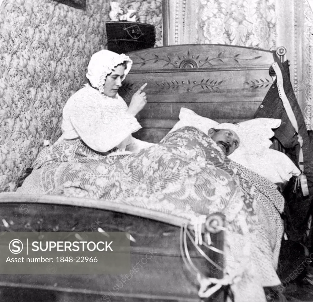 Historic photograph, woman scolding her husband in bed, around 1900