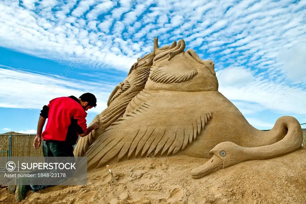 Man creating a sand sculpture
