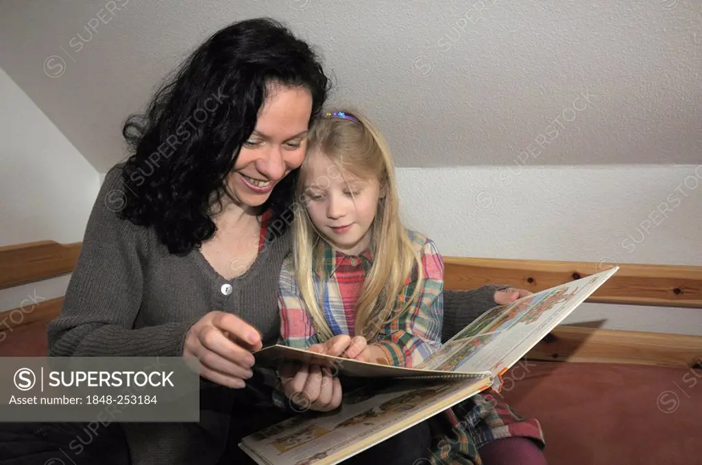 Mother with child, 10 years old, reading a book