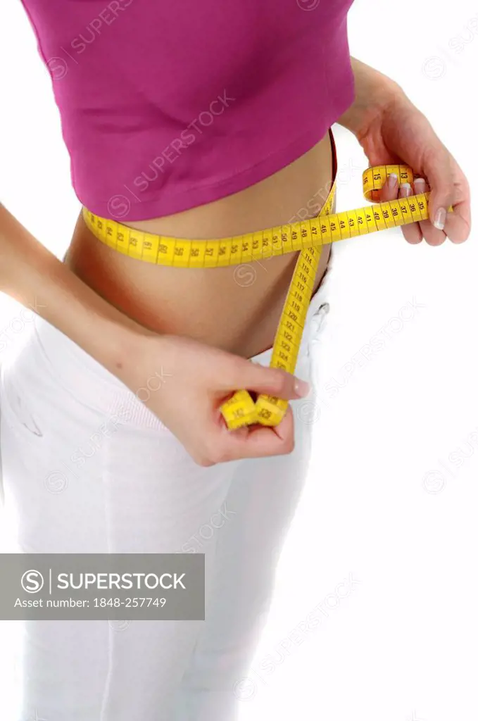 Young woman measuring her waist circumference with a measuring tape