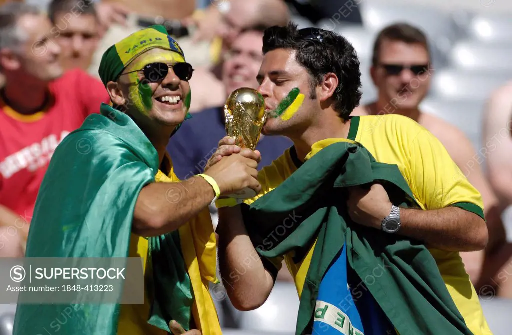 Brazilian football fans kissing a model of the World Cup, Football World Cup 2006 in Germany