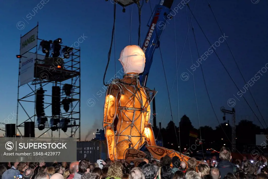 Giant illuminated figure on ropes walking through the audience, Global Rheingold, open-air theater by La Fura dels Baus, Duisburg-Ruhrort, Ruhrgebiet ...