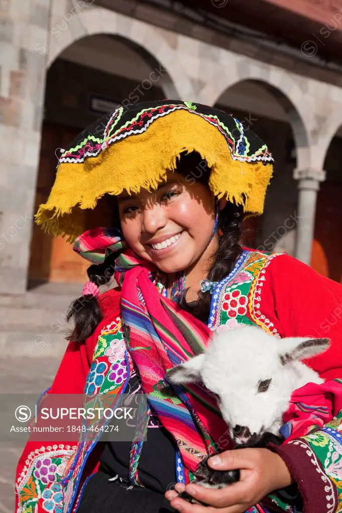 Pretty Peruvian girl with a lamb and traditional costume in Cusco, Peru, South America