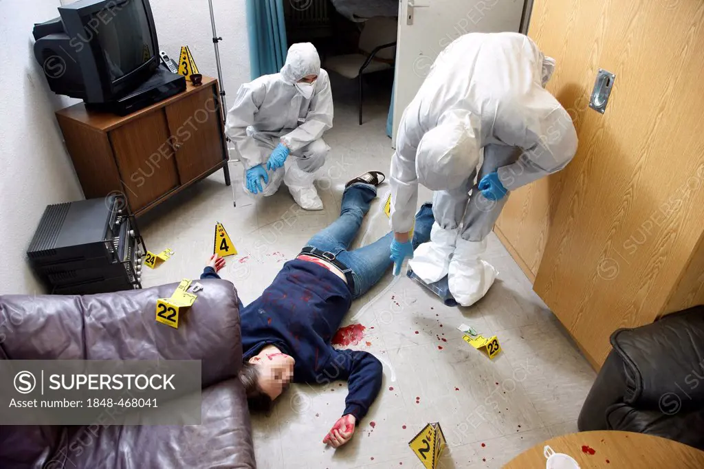 The position of a victim is marked with chalk spray, officers of the C.I.D., the Criminal Investigation Department, gathering forensic evidence at a c...