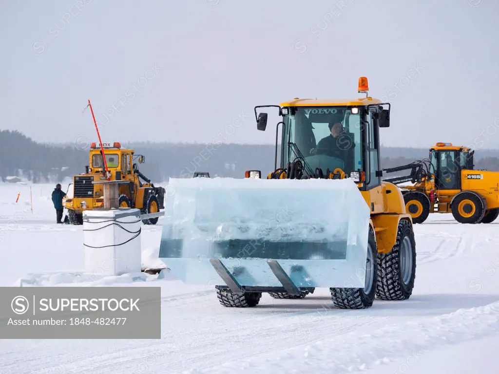 Near the ice hotel in Jukkasjaervi, large blocks of ice are cut and lifted from the frozen Torne Aelv River with heavy equipment, Jukkasjaervi, Kiruna...