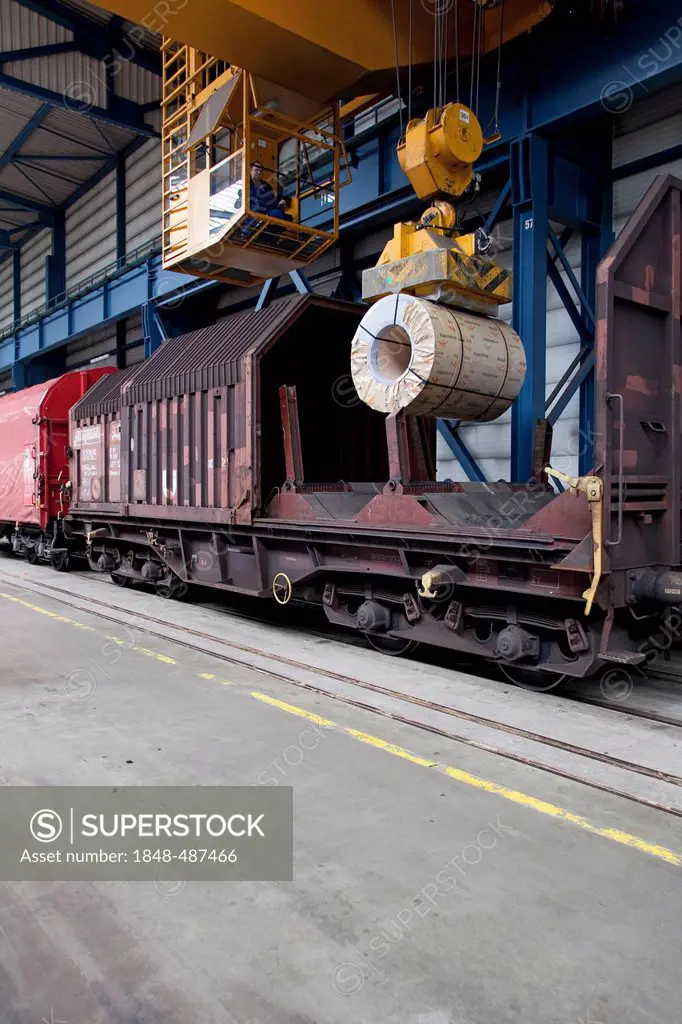 Loading of finished flat steel rolls onto a freight train using a crane with a strong electromagnet, steelworks of ArcelorMittal, Eisenhuettenstadt, B...