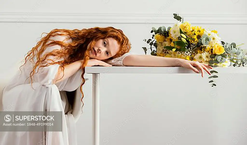 Beautiful woman posing with bouquet spring flowers table