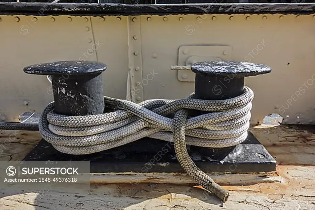 Secured mooring line, mooring rope, hawser laid in a figure-8 pattern  around shipboard bitts on deck of ship - SuperStock