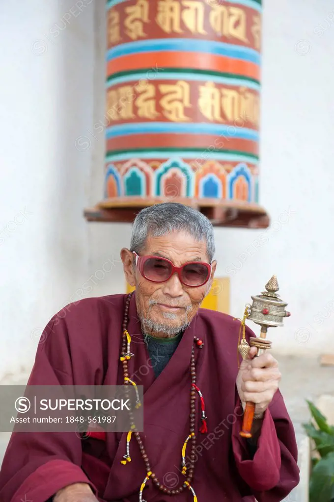 Tibetan Buddhism, believer with large sunglasses spinning a small prayer wheel, Thimphu, the Himalayas, Kingdom of Bhutan, South Asia, Asia
