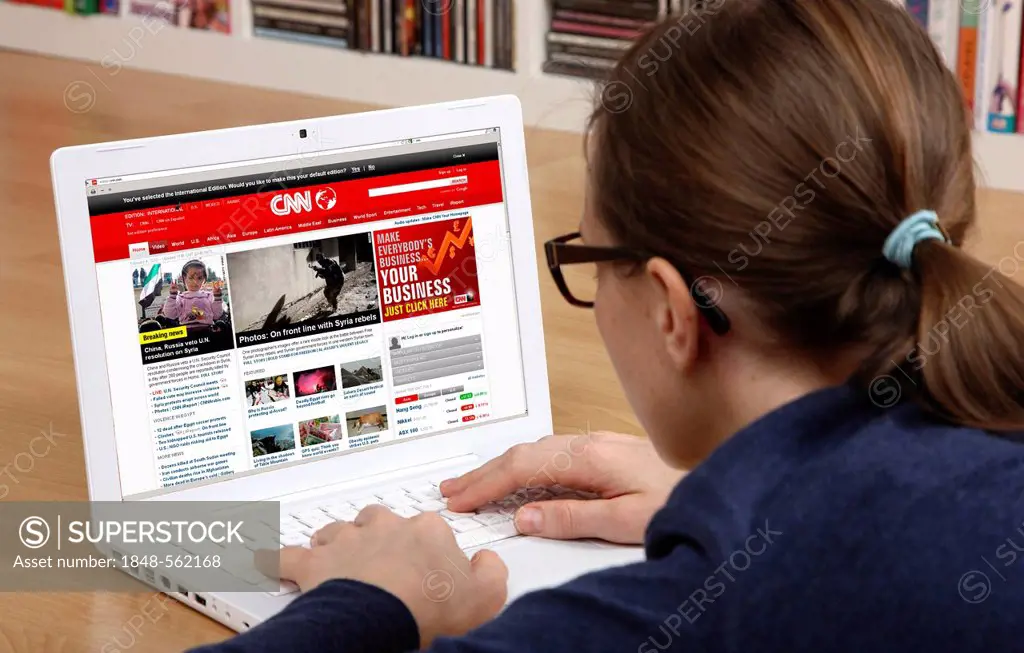 Woman surfing the internet with a laptop, website of the US news channel CNN