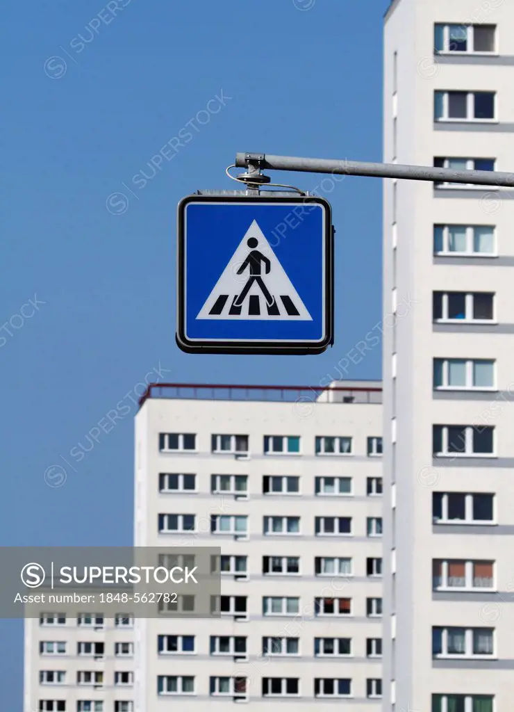 Pedestrian crossing sign in front of apartment buildings