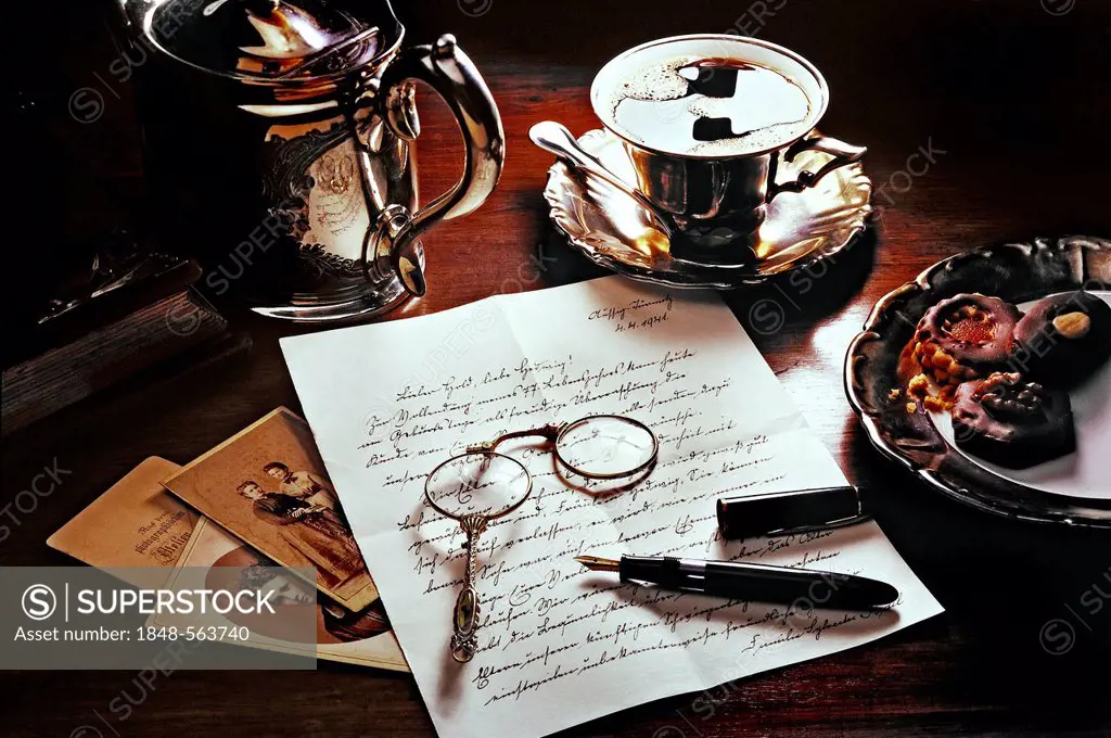 Old letter with coffee, cookies, fountain pen, photos and a lorgnette