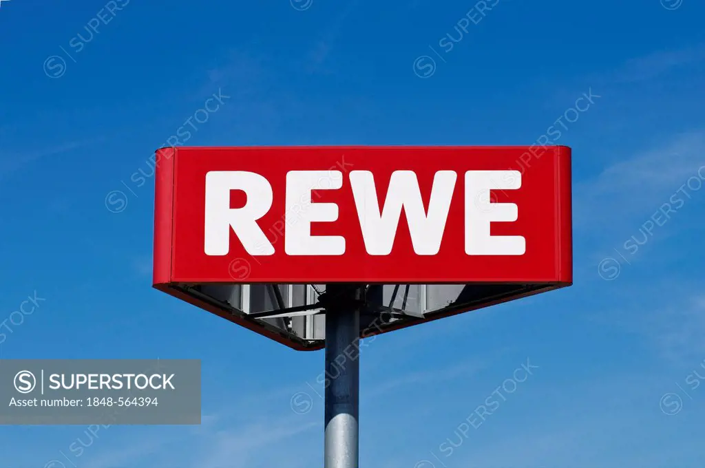 Logo of REWE supermarket chain against blue sky