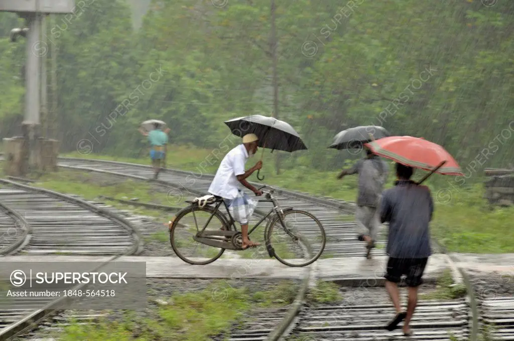 Cyclists and pedestrians in heavy rain, railway crossing in Kalawewa, Sri Lanka, Ceylon, South Asia, Asia, PublicGround