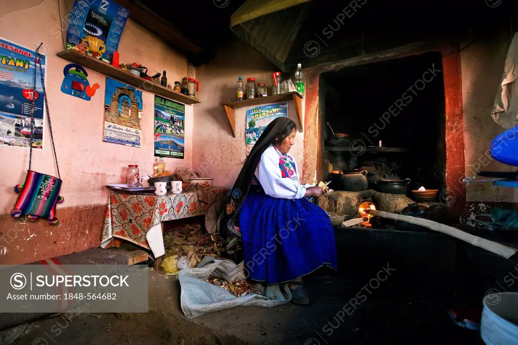 Housewife at the hearth in her kitchen, wearing the traditionell clothes of the Amantani-Quechua, Isla Amantani in Lake Titicaca, Amantani, Peru, Sout...