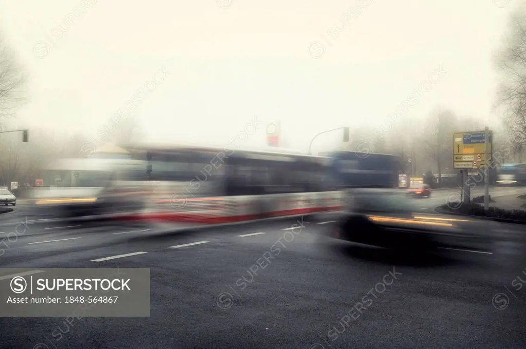 Morning traffic at an intersection in the early morning mist, motion blur