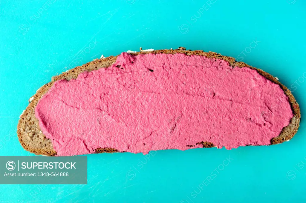 Organic bread with a horseradish-beetroot spread on a cutting board
