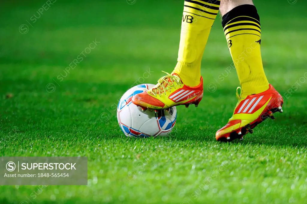 Legs and Adidas shoes of a Dortmund player with the league ball, preparatory match for the second round of the tournament season 2011-2012, Fortuna Du...