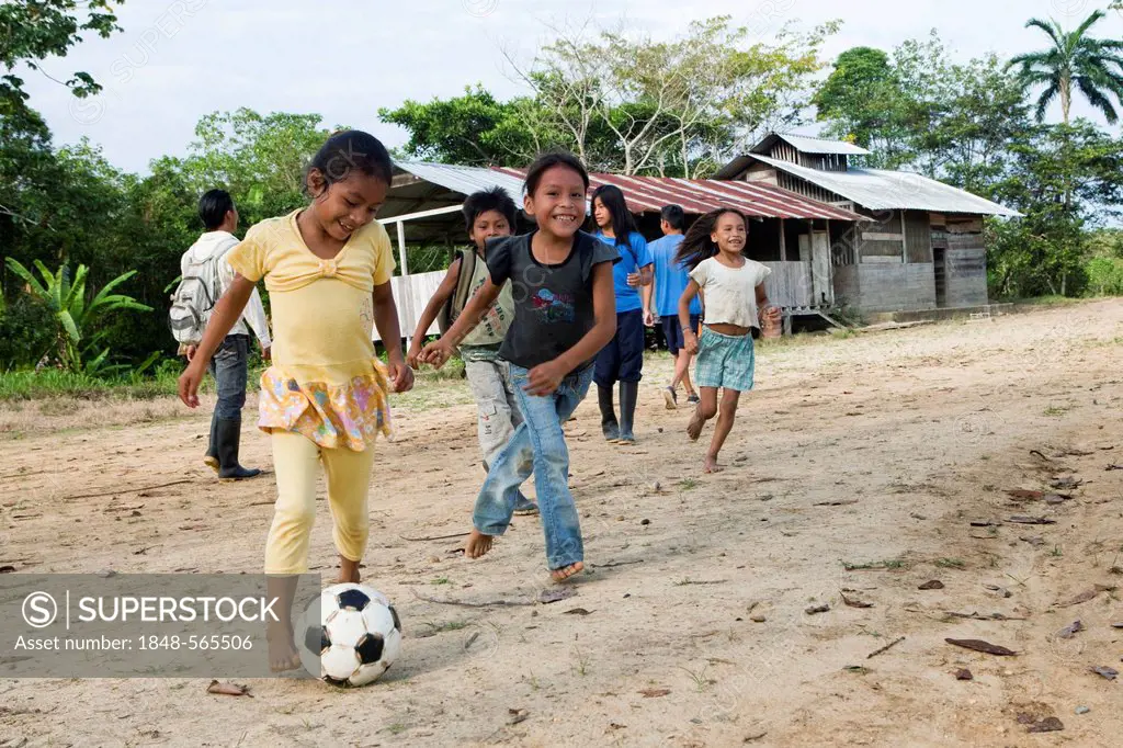 School children playing soccer in the schoolyard before classes start in a village with no road access in the rainforest of the Oriente, Curaray, Ecua...