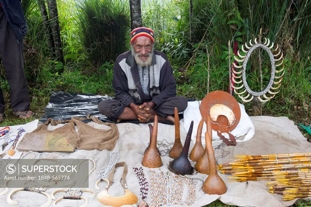 Man selling penis gourds, pig tusks and various other items at Paiya Show, Western Highlands, Papua New Guinea, Oceania