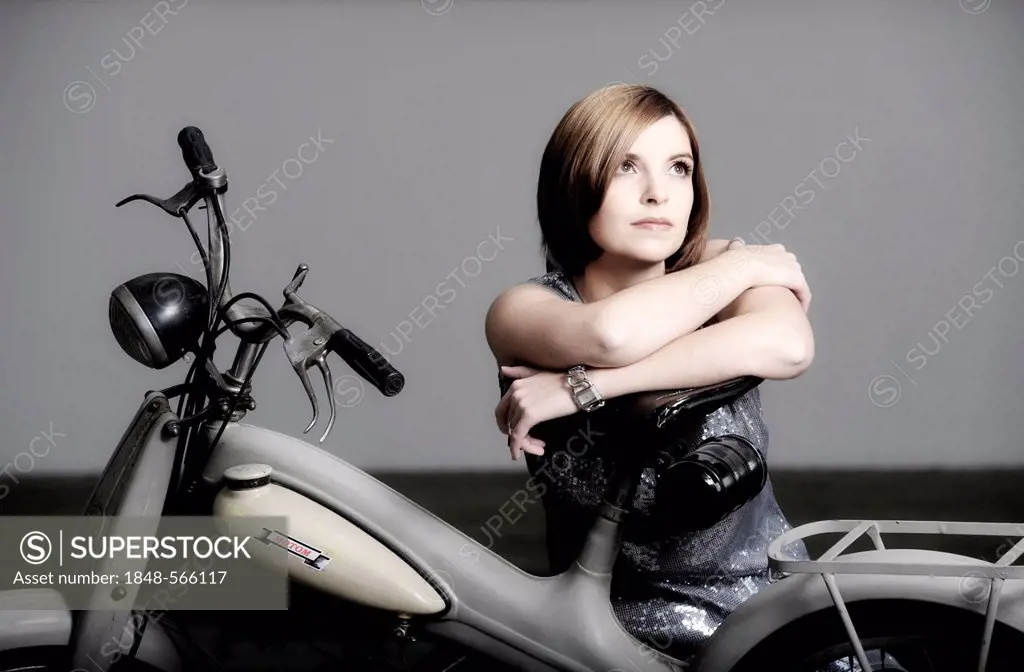 Young woman with a vintage Motom motorcycle