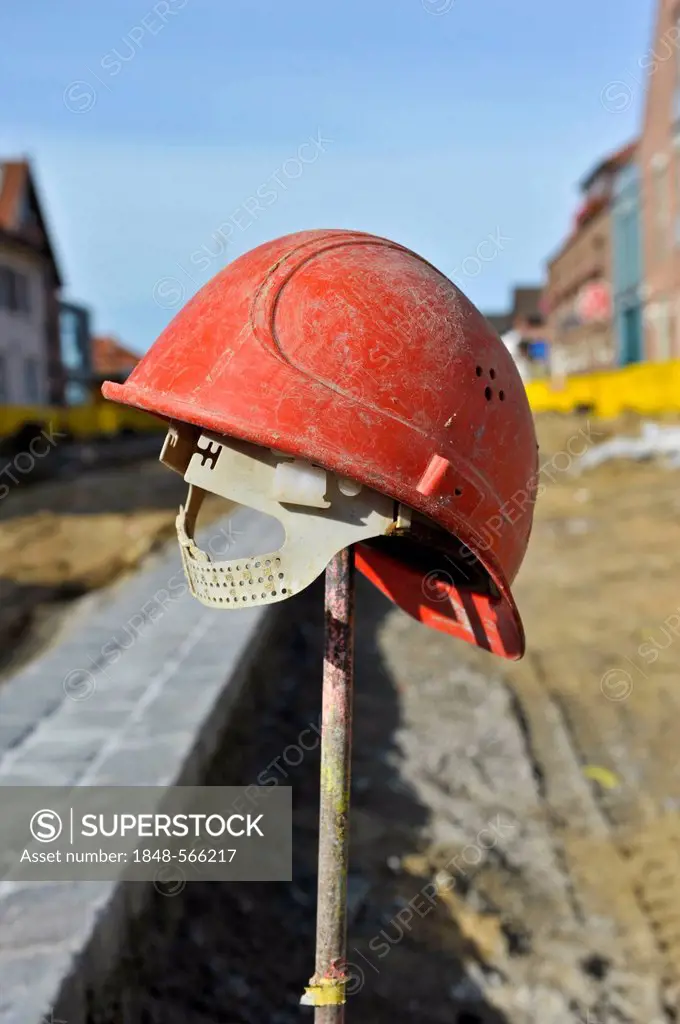 Red hard hat on an iron rod