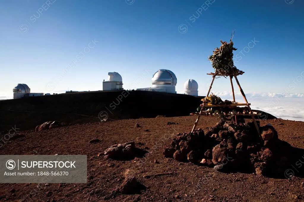 Hawaiian temple on the summit of the Mauna Kea Volcano, 4205m, part of the Mauna Kea Observatory on the horizon, Mauna Kea, Hawai'i, USA