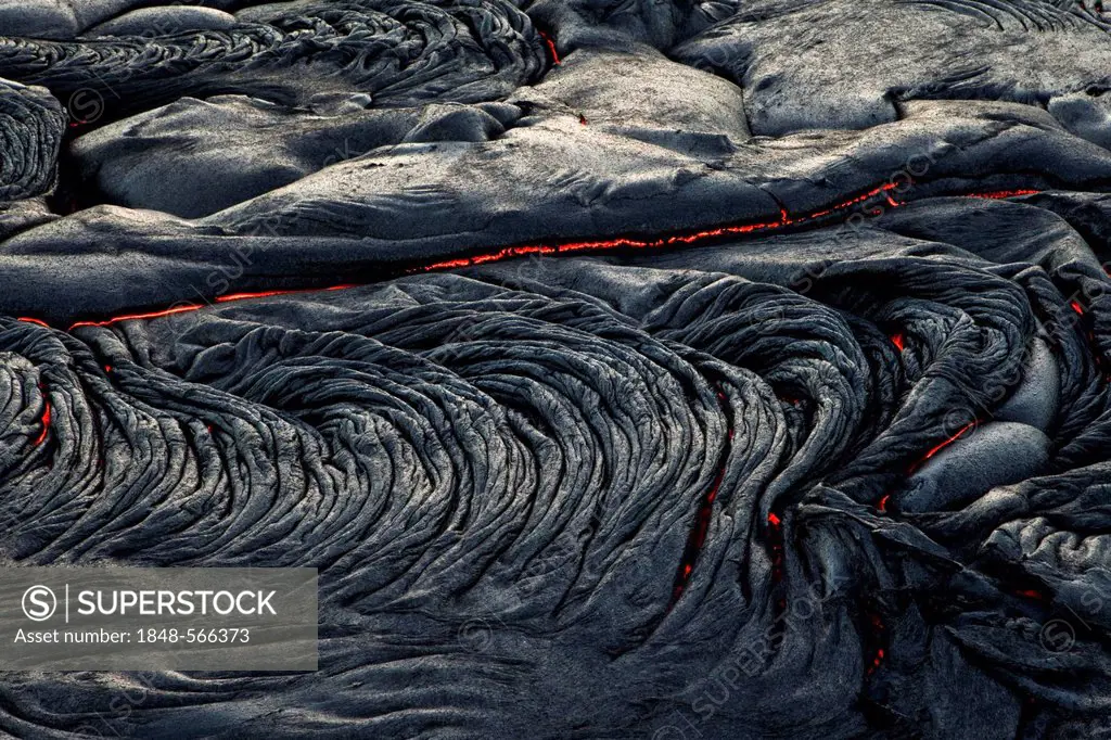 Molten pahoehoe type lava flowing from a crack in the East Rift Zone towards the sea, lava field of the Kilauea shield volcano, Hawai'i Volcanoes Nati...