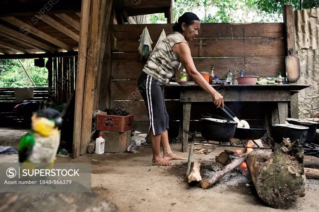 Carlota, from the Quechua people, preparing breakfast in her kitchen, in a village with no road access in the rainforest of the Oriente, Curaray, Ecua...