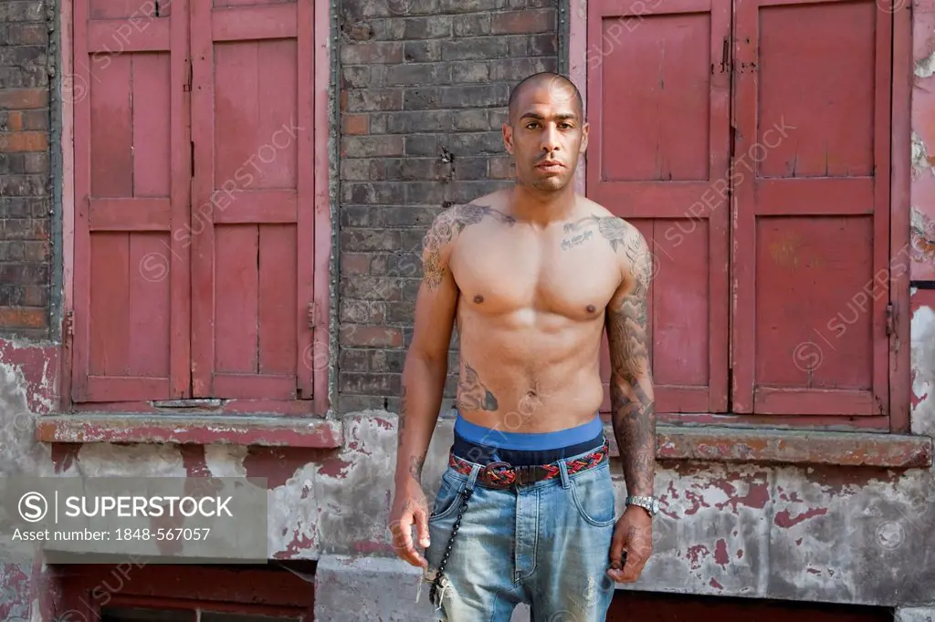 Bare-chested mixed-race British man with tattoos, East End, London, England, United Kingdom, Europe