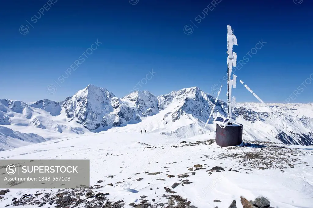 Cross-country skiers on the summit of Hintere Schoentaufspitze Mountain with the weather station, Solda in winter, with Koenigsspitze, Ortler and Zebr...