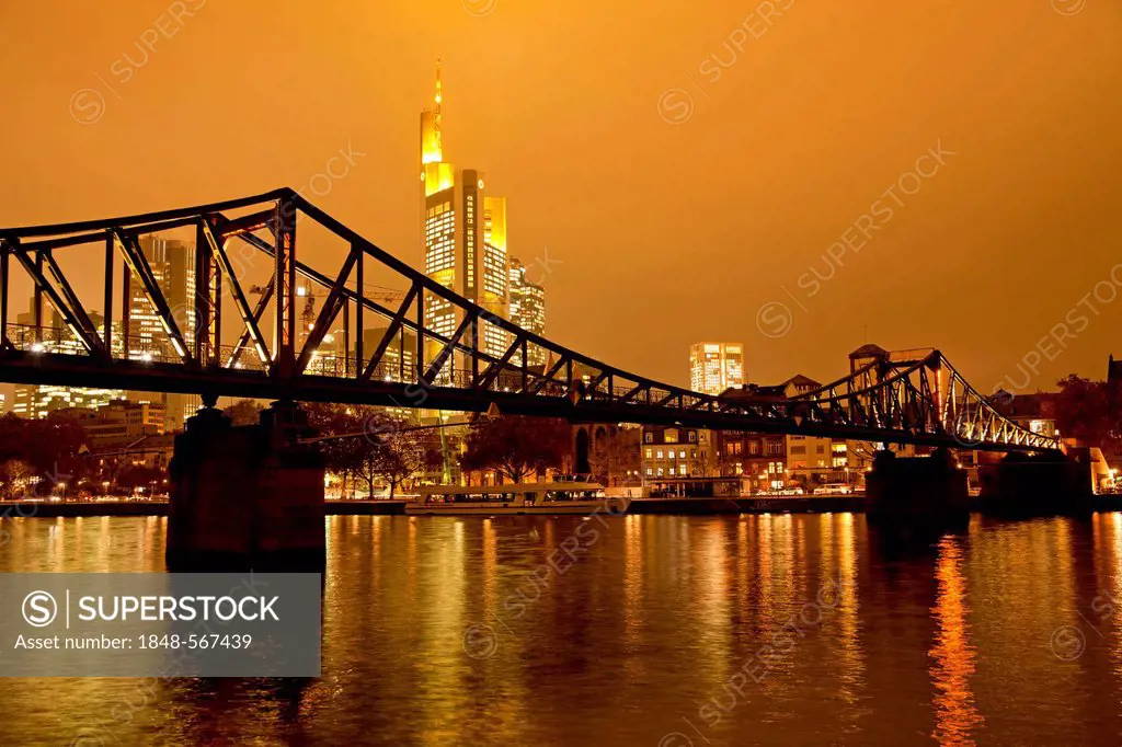 Eiserner Steg Bruecke, bridge over the Main river with the illuminated skyline of Frankfurt at dusk, Frankfurt am Main, Hesse, Germany, Europe