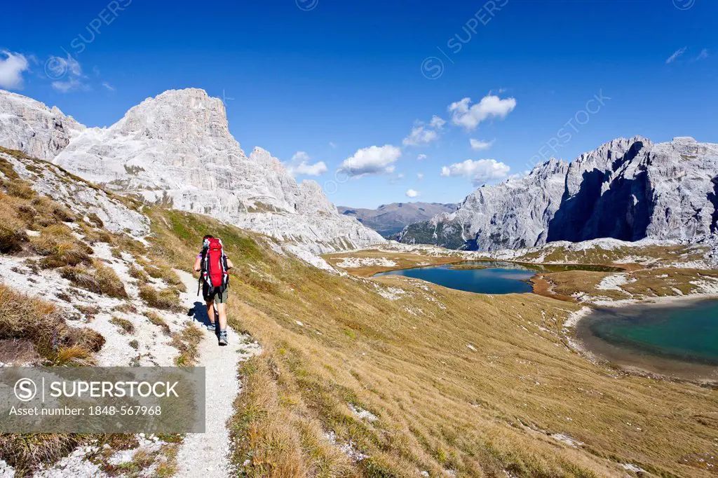 Hiker at the Boedenseen lakes while descending from Three Peaks Hut, Schusterplatte Mountain on the left, Einser Mountain on the right, Croda Rossa di...