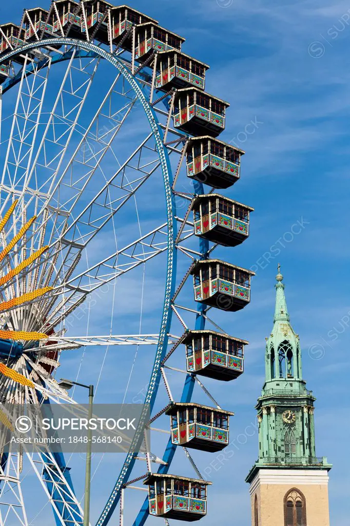 A ferris wheel and Marienkirche church on Alexanderplatz square, Berlin, Germany, Europe