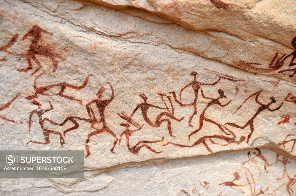 Group of painted warriors or hunters, neolithic rockart at Arakokem, Adrar Tekemberet, Immidir, Algeria, Sahara, North Africa