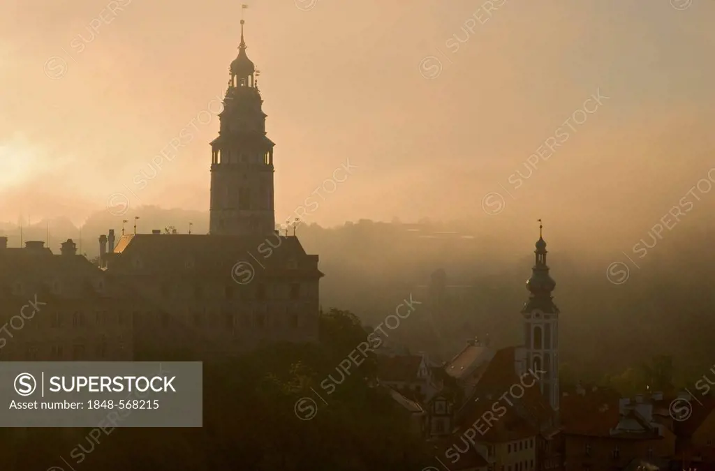 Ceský, Cesky Krumlov with the towers of the castle on the left and of St. Jost church on the right, in thick morning fog, Jihoceský, Jihocesky kraj, S...
