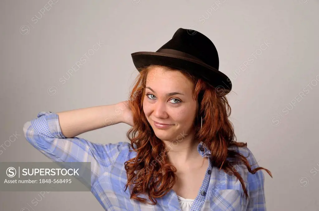 Young woman with red hair wearing a brown felt hat