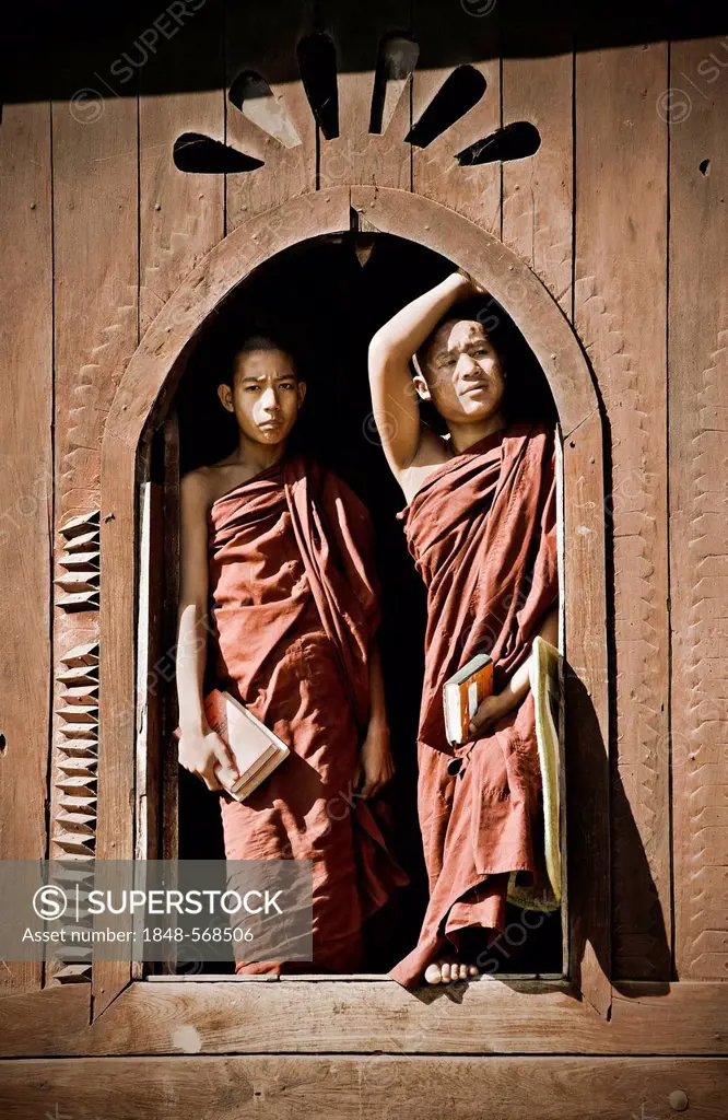 Two monks standing at a window of the Shwe Yan Bye monastery in Burma, Myanmar, Southeast Asia, Asia